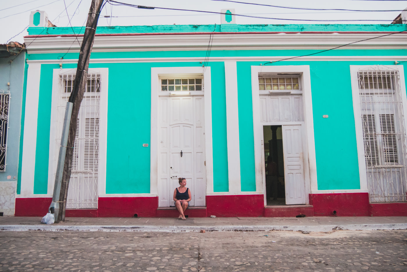 Julia vor einer bunten Hausfassade in Trinidad