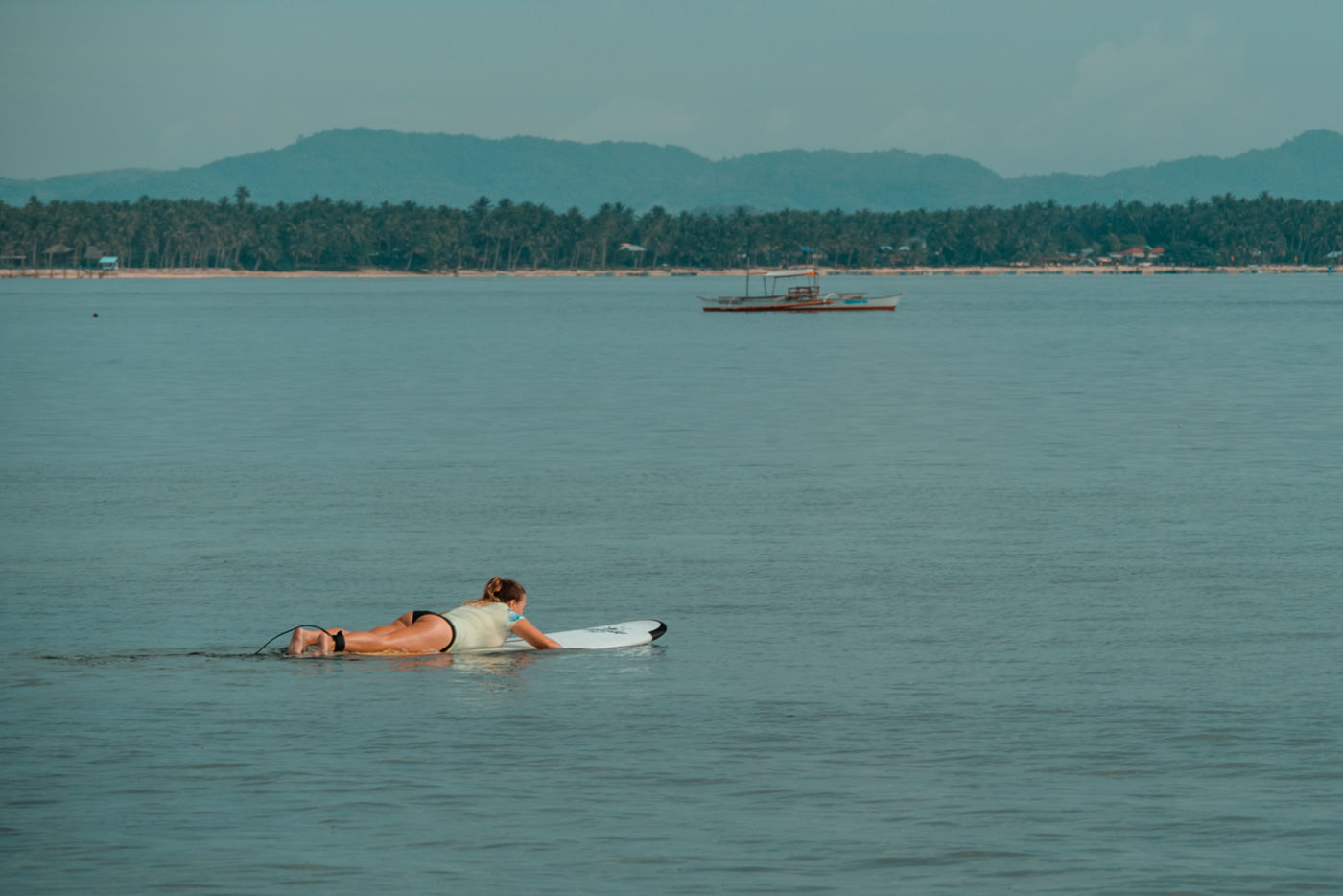 Julia paddelt raus zum surfen auf Siargao Island