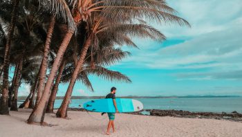 Matthias mit dem Surfbrett am Strand