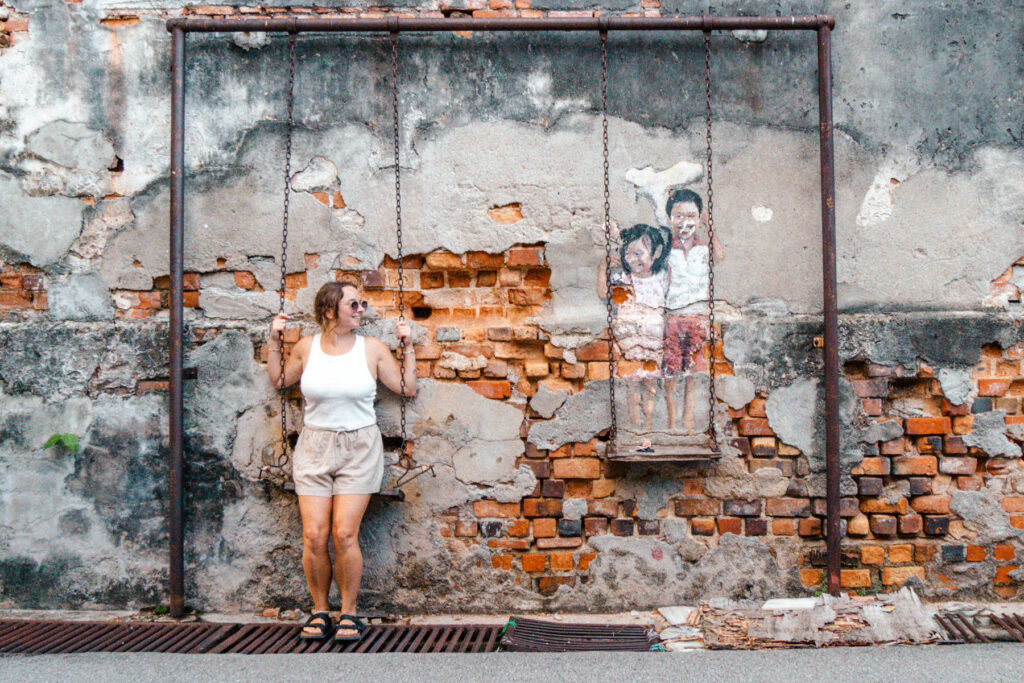 Julia auf einer Schaukel und Streetart in George Town Malaysia